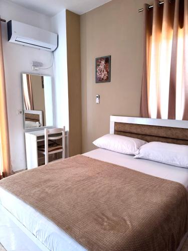 a bedroom with a large bed and a mirror at Vila Spiro in Ksamil