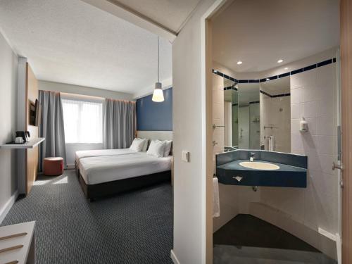 una camera d'albergo con un letto e un lavandino di Holiday Inn Express Antwerpen City North by IHG ad Anversa