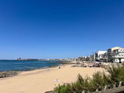 - une plage avec des personnes, des bâtiments et l'océan dans l'établissement Les Océanes, à Les Sables-dʼOlonne