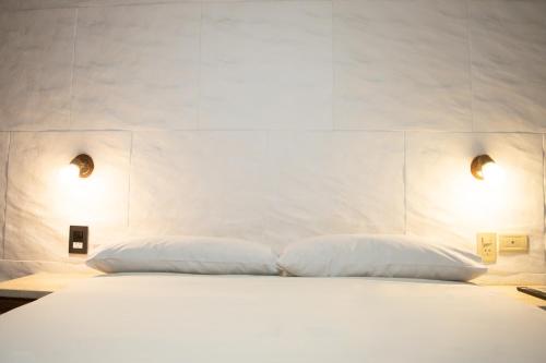 a bedroom with a white bed with two pillows at Hotel del Monumento in Salta