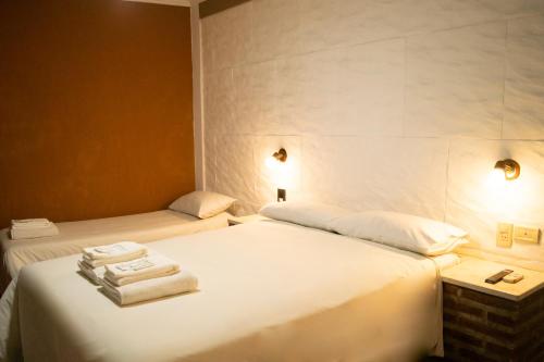 a hotel room with two beds with towels on them at Hotel del Monumento in Salta