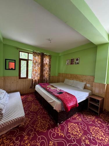 a bedroom with green walls and a bed and a window at tabocoffeehouse in Tabo