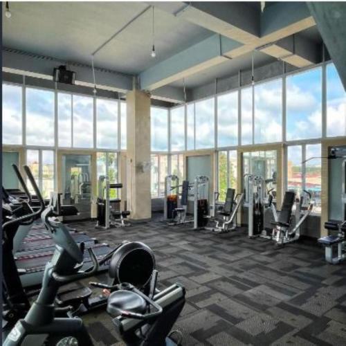 a gym with cardio equipment in a large room with windows at Alltrue Sydney Hotel Batam Center in Batam Center