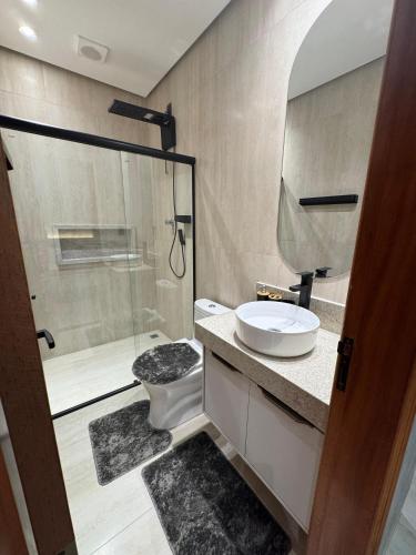 a bathroom with a shower and a toilet and a sink at Apartamento 424 Alter do Chão - Ilha Bela Residence in Santarém