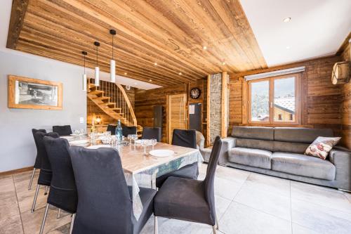 une salle à manger avec une table, des chaises et un canapé dans l'établissement Chalet - Le Galibier, à Valloire