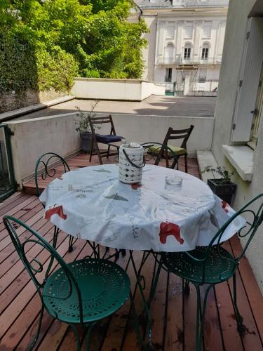 une table et des chaises sur une terrasse avec une nappe blanche dans l'établissement Chez Matteo T2 35 m ,parking privé securise terrasse 15m local skis 300m des remontées mécaniques, à Luchon