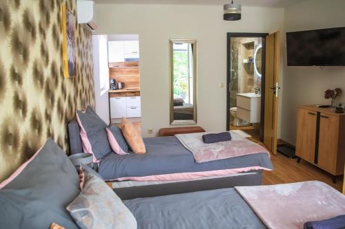 a bedroom with two beds and a bathroom at Oázis Tapolca Apartman in Miskolctapolca