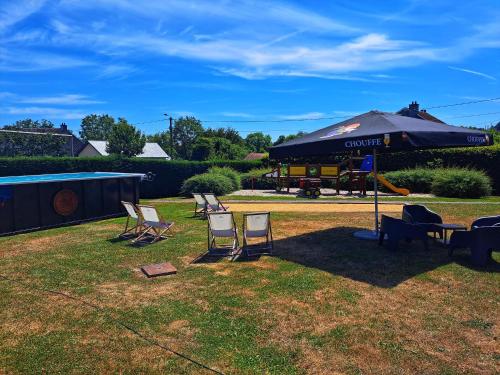 a group of chairs and an umbrella in a yard at Hotel & Restaurant Maison Pal'Ange in Durbuy