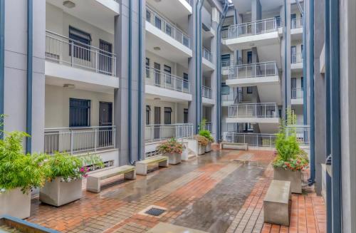 an empty courtyard of an apartment building with potted plants at Atrium Oasis, Sandton in Johannesburg