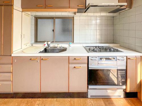 a kitchen with a sink and a stove at 渡边ビル402 in Tokyo