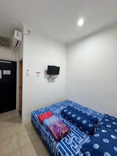 a bedroom with a bed and a flat screen tv at SATU Hotel by Taslim Gading Serpong in Tangerang