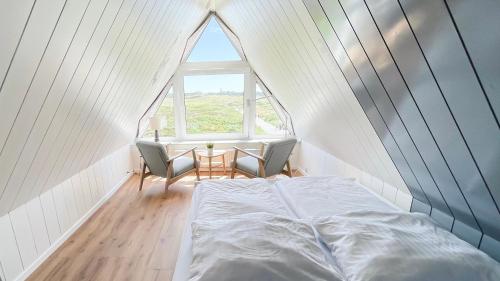 ヘルヌムにあるHickory Hideawayの大きな窓のある部屋のベッド