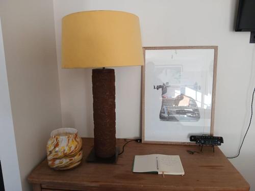a lamp on top of a wooden table with a mirror at The Jacob House in Maldegem