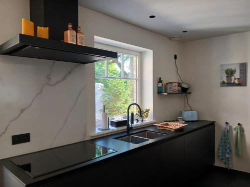 a kitchen with a sink and a window at The Jacob House in Maldegem