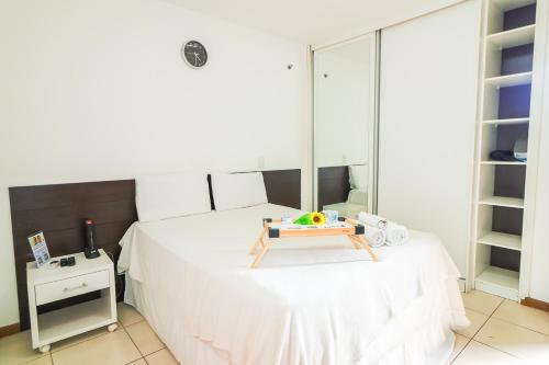 a bedroom with a bed with a tray on it at OZPED Flats Particulares Edifício Life Resort in Brasilia