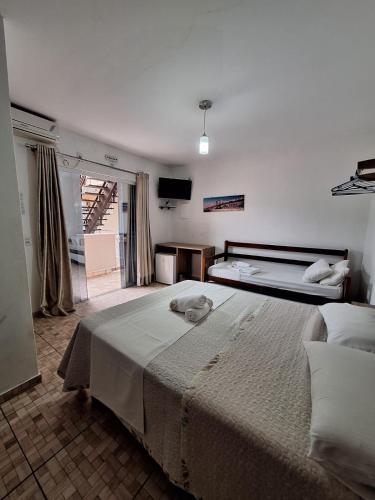 a bedroom with two beds and a television in it at Coração Do Oceano Village in Penha