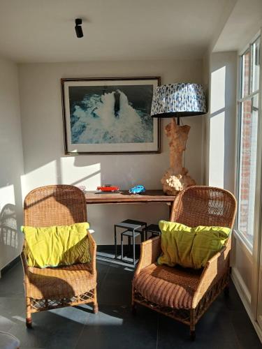 a living room with two chairs and a table at The Jacob House in Maldegem