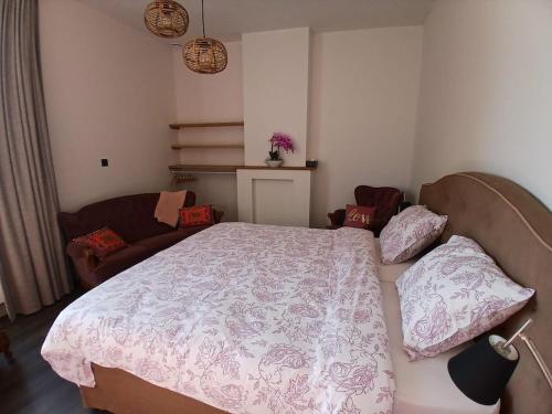 a bedroom with a bed and a couch at The Jacob House in Maldegem