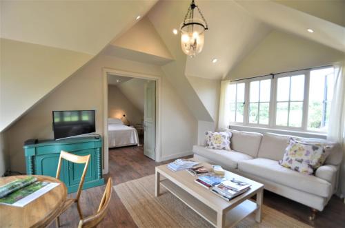 a living room with a couch and a tv at The Lakehouse Apartment by inspirestays-com in Rudgwick