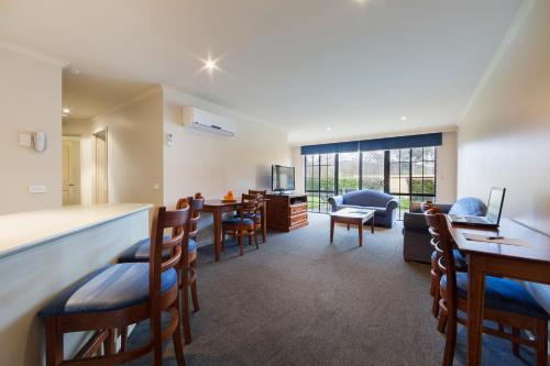 a living room with a bar and a dining room at Canberra Parklands Central Apartment Hotel Official in Canberra
