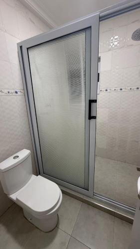a bathroom with a toilet and a glass shower at 3 Bedroom House In Oyarifa - Accra in Trofwi