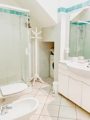a white bathroom with a sink and a toilet at La Casina di Giuliana in Principina a Mare