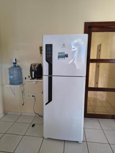 a white refrigerator in a kitchen with a door at Sol e Praia in Prado