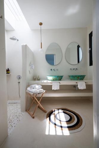 a bathroom with a sink and two mirrors at Myconian Theros Luxury Suites in Ano Mera