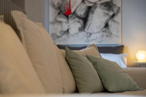 a pile of pillows on a couch with a painting at Filina House in Neos Marmaras