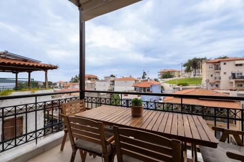 a wooden table on a balcony with a view of the ocean at Filina House in Neos Marmaras