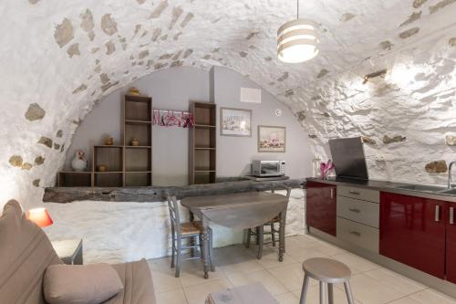 - une cuisine avec un mur en pierre et une table dans une chambre dans l'établissement Belle Maison En Pierre Avec Piscine, à Berrias Et Casteljau