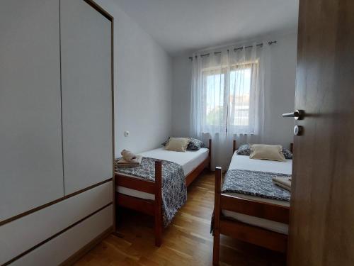 マリンスカにあるApartment Josipaのベッド2台と鏡のある小さな部屋