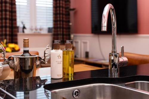 a kitchen counter with two bottles of wine next to a sink at The Highland Club in Fort Augustus