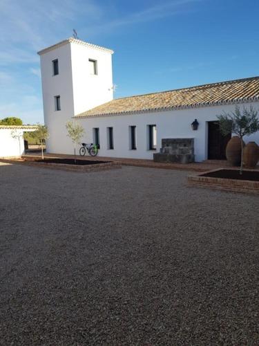 a white building with a bike parked in front of it at Casa Rural Finca El Tobar in Ossa de Montiel