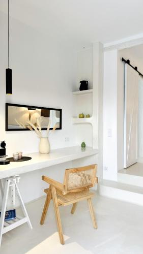 a white room with a desk and a bench at Myconian Theros Luxury Suites in Ano Mera