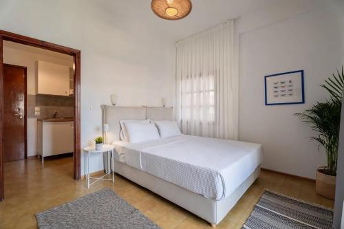 a bedroom with a large white bed and a table at Filina House in Neos Marmaras