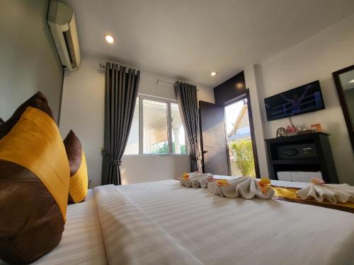 a bedroom with a large white bed with pillows at Sun Chakra Boutique Hotel - 50m to Museum & Royal Palace & Walking street in Phnom Penh