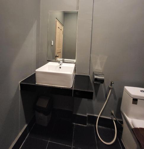 a bathroom with a sink and a mirror and a toilet at Sun Chakra Boutique Hotel - 50m to Museum & Royal Palace & Walking street in Phnom Penh