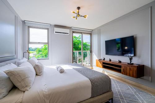 a bedroom with a large bed and a flat screen tv at Glorious 1BR with Balcony in Panama Pacifico in Playa Bonita Village