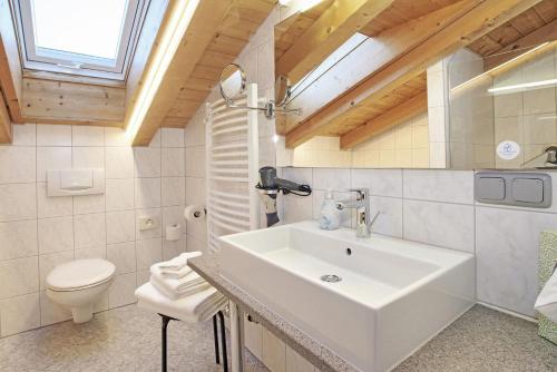 a bathroom with a white sink and a toilet at Gästehaus und Ferienwohnungen Egglerlehen in Schönau am Königssee