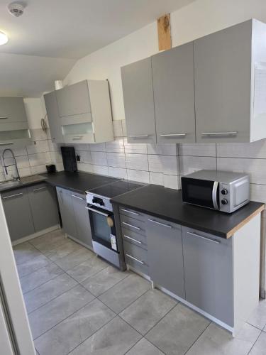 a kitchen with white cabinets and a microwave on a counter at Pyrzowice noclegi AirNest 8 min od Lotniska Katowice Airport 