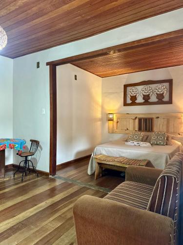 a large bedroom with two beds and a couch at Suítes Lar Doce Lar in Lavras Novas