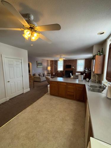 a kitchen with a ceiling fan and a living room at Hermann Crown Suites in Hermann