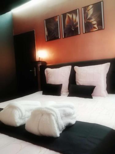 une chambre avec un lit avec des draps blancs et des oreillers dans l'établissement Appartements avec balnéo et sauna privatif - Troyes Centre, à Troyes