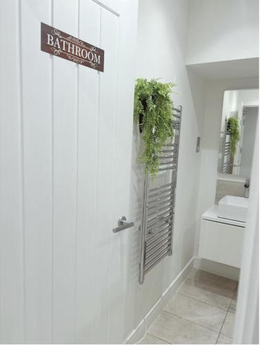 a bathroom with a toilet and a sign on the wall at Barbican Boutique Luxury Apartments & Rooms, Plymouth in Plymouth