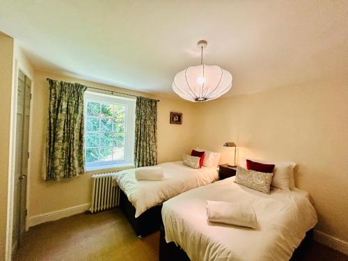 two beds in a room with a window at Quarry Cottage - Snug Hideaway in Box