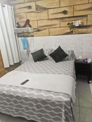 a bed with black pillows on it in a room at Casa COP Maria bonita in Belém