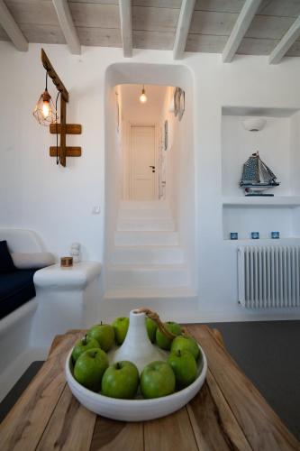a bowl of green apples on a table in a room at Myconian Theros Luxury Suites in Ano Mera
