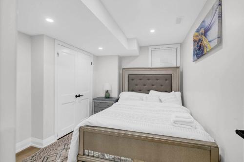 a bedroom with a large bed with white walls at Your Luxurious Caledon Escape in Brampton