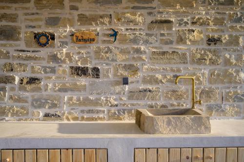 een stenen muur met een gootsteen ervoor bij Villa Callistemon in Pitsidia